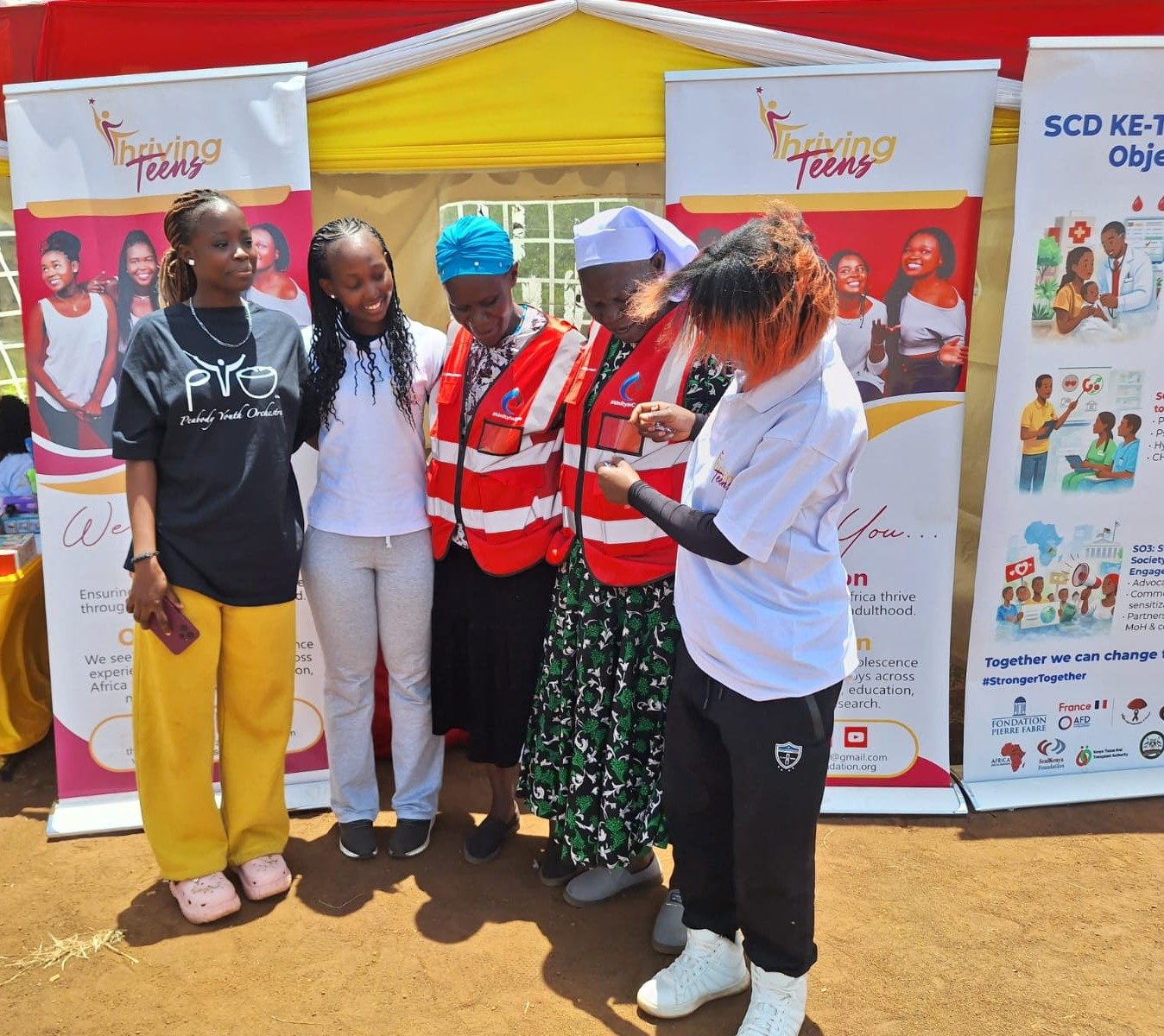 Thriving Teens Foundation with community health partners at an SCD Kenya outreach tent